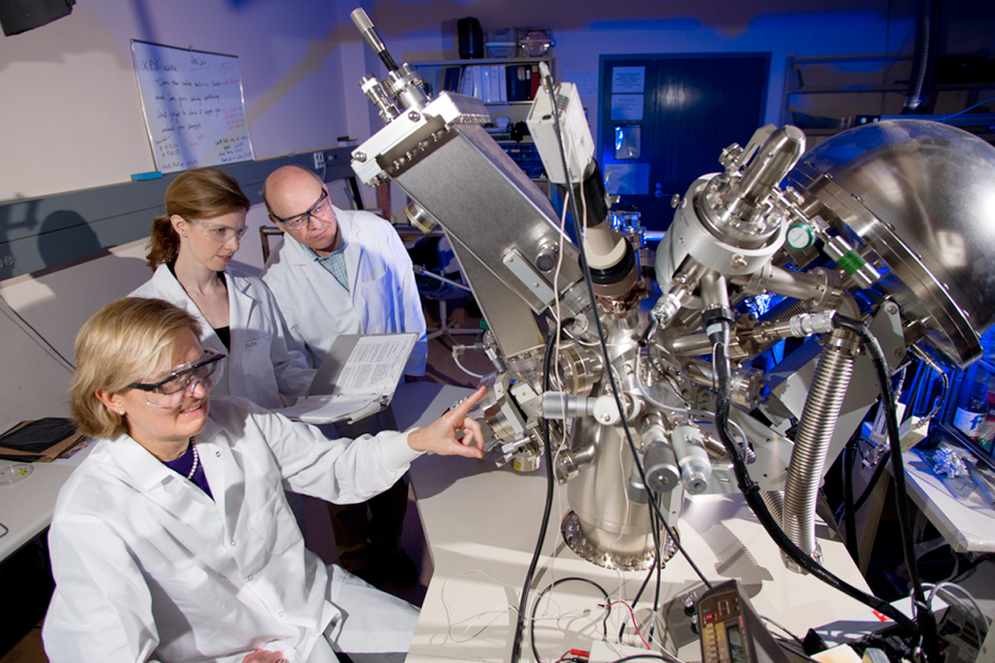 researchers around lab equipment